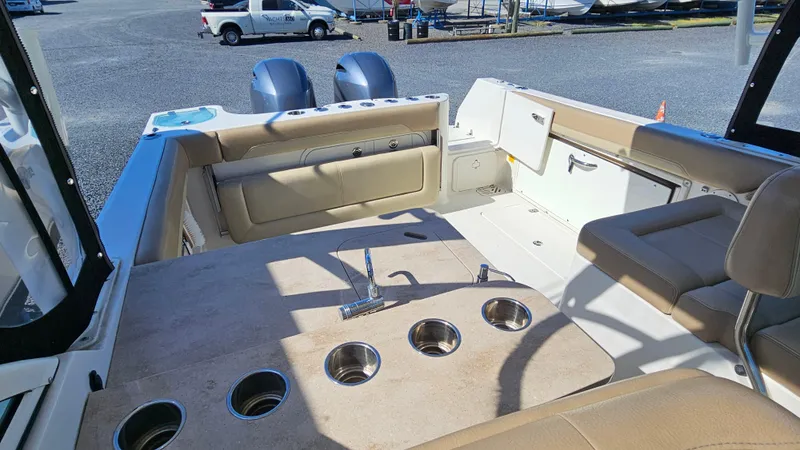 Slide: The Image of 2019 Sailfish 275 DC boat interior with seating, cup holders, and dual outboard motors. - 15
