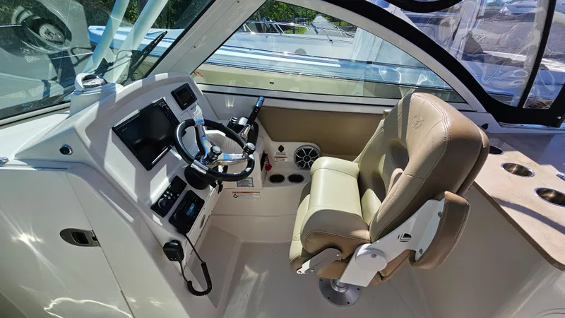 Slide: The Image of 2019 Sailfish 275 DC boat cockpit with steering wheel and captain's chair. - 23