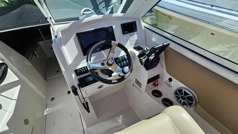 Slide: The Image of 2019 Sailfish 275 DC boat cockpit with steering wheel and control panel. - 24