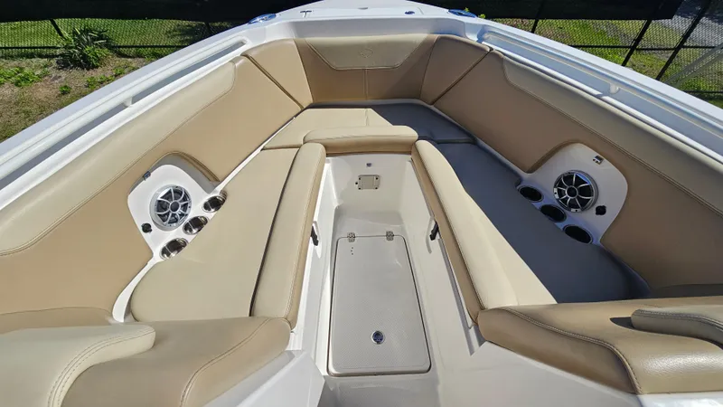 Slide: The Image of 2019 Sailfish 275 DC boat interior with beige seating and built-in speakers. - 30