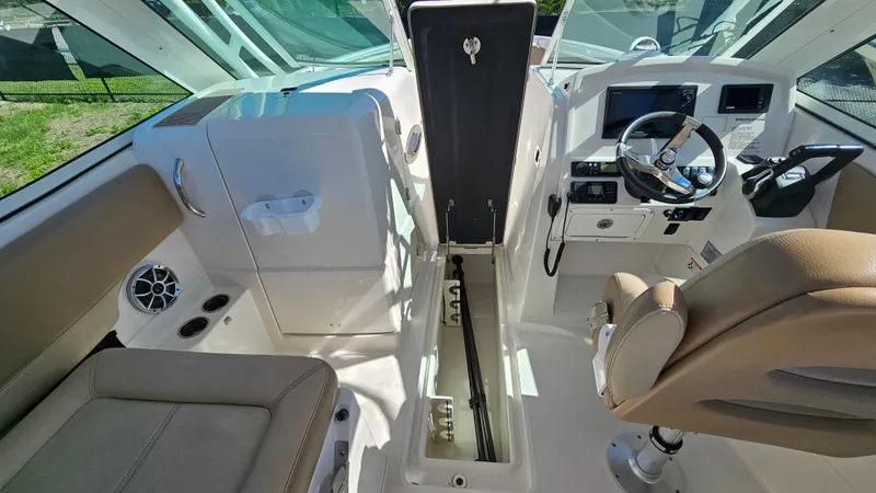 Slide: The Image of 2019 Sailfish 275 DC boat interior with open storage, steering wheel, and seating. - 37