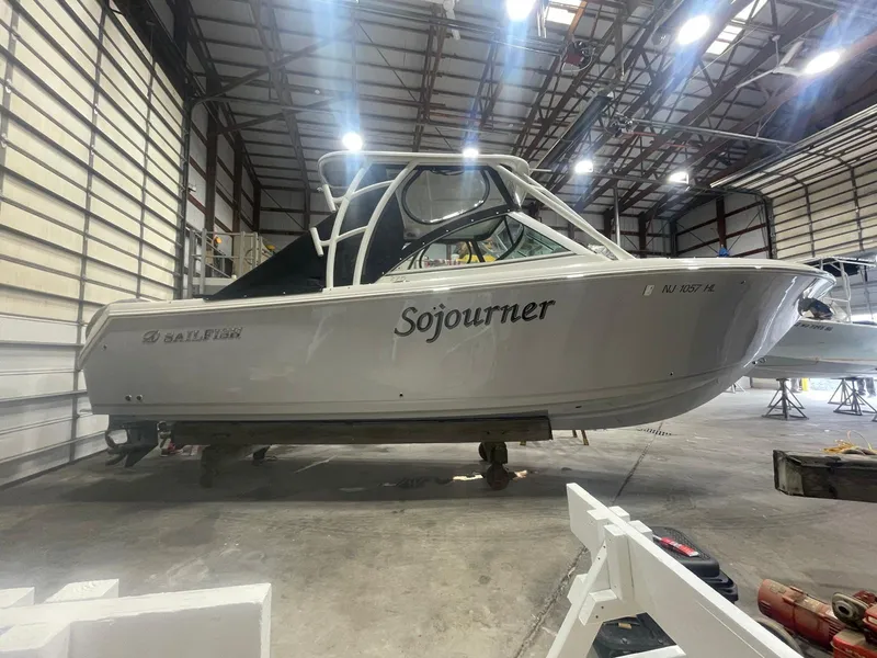 Slide: The Image of 2019 Sailfish 275 DC boat named "Sojourner" in a spacious indoor storage facility. - 39