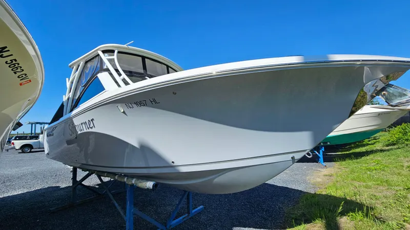 Slide: The Image of 2019 Sailfish 275 DC boat on display, parked on a stand under clear blue sky. - 6