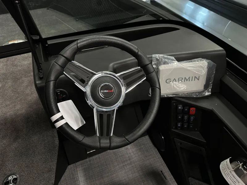 Slide: The Image of 2025 Alumacraft Competitor 175X Sport dashboard with steering wheel and Garmin device. - 13
