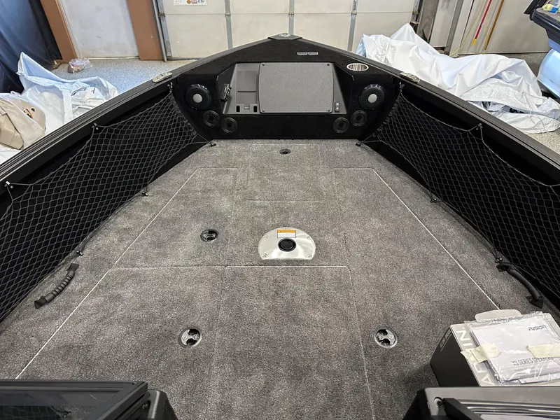 Slide: The Image of 2025 Alumacraft Competitor 175X Sport boat interior with carpeted deck and storage compartments. - 18