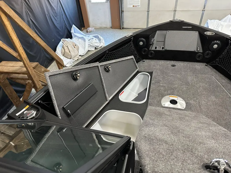 Slide: The Image of 2025 Alumacraft Competitor 175X Sport interior with storage compartments and control panel. - 19