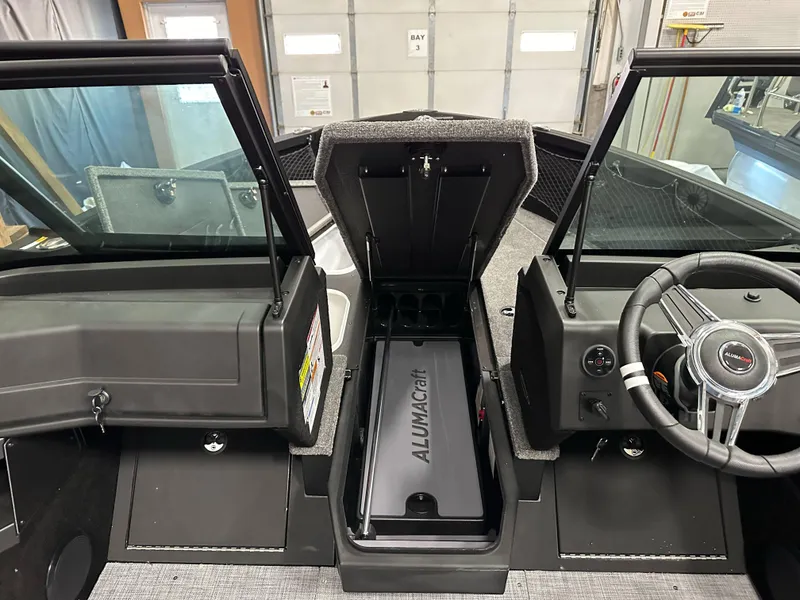 Slide: The Image of 2025 Alumacraft Competitor 175X Sport boat interior with steering wheel and storage compartment. - 20
