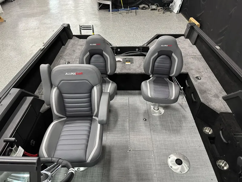 Slide: The Image of 2025 Alumacraft Competitor 175X Sport interior with two gray seats and carpeted flooring. - 22