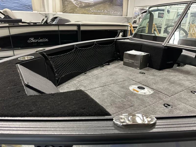 Slide: The Image of 2025 Alumacraft Competitor 175X Sport boat interior with carpeted deck and storage features. - 7