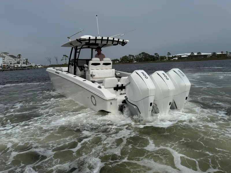 Slide: The Image of 2019 Fountain 34 CC boat with triple outboard engines cruising on water. - 17