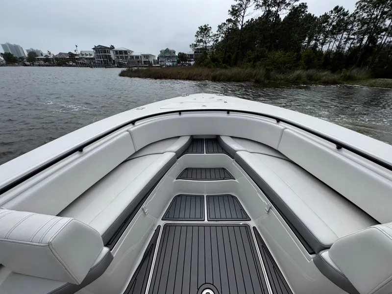 Slide: The Image of 2019 Fountain 34 CC boat interior with white seating, on a calm lake. - 19