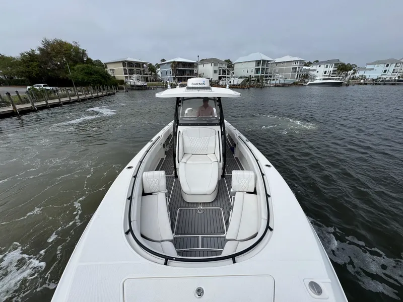 Slide: The Image of 2019 Fountain 34 CC boat cruising in a coastal residential area. - 21