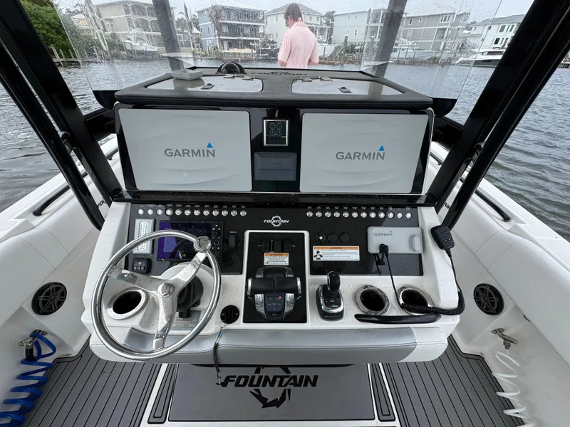 Slide: The Image of 2019 Fountain 34 CC boat dashboard with Garmin navigation systems and steering wheel. - 29