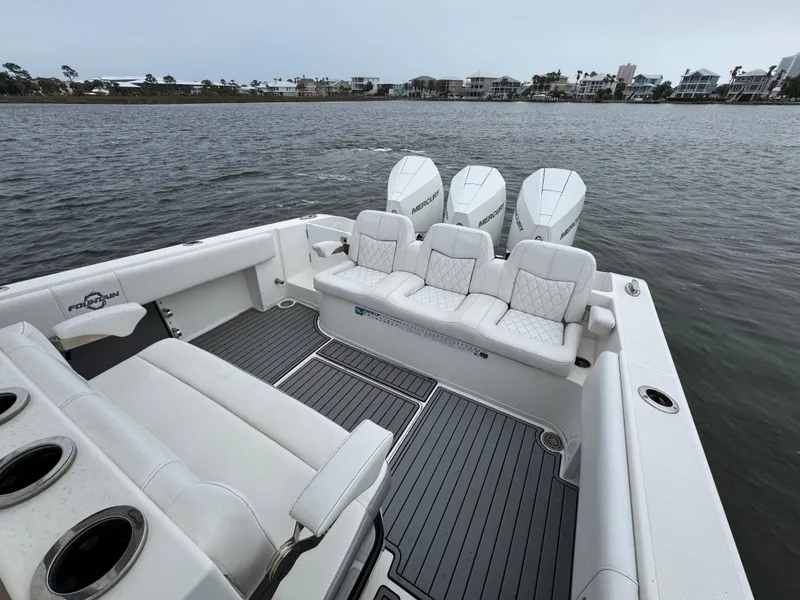 Slide: The Image of 2019 Fountain 34 CC boat with triple engines, spacious seating, and sleek design on calm water. - 31