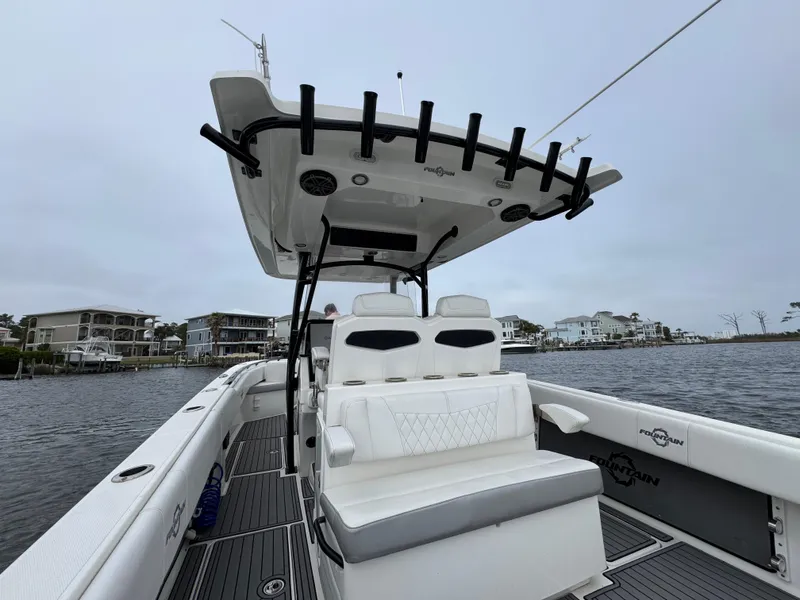 Slide: The Image of 2019 Fountain 34 CC boat with seating, docked near waterfront homes. - 33