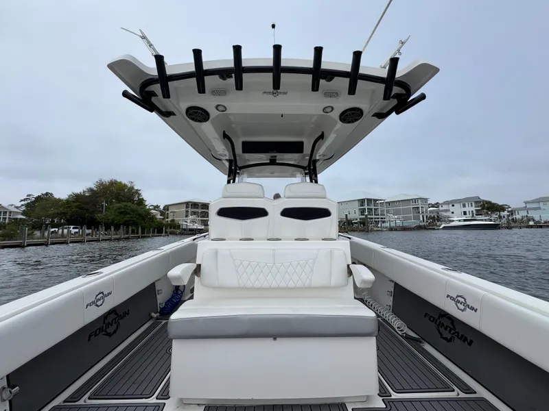 Slide: The Image of 2019 Fountain 34 CC boat with seating, docked near waterfront homes. - 34