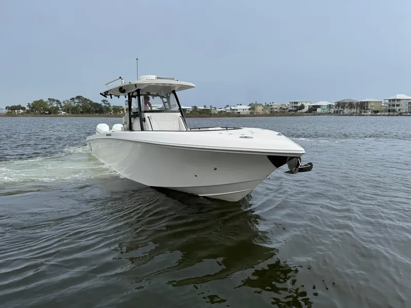 Slide: The Image of 2019 Fountain 34 CC boat cruising on a calm lake with distant shoreline. - 7