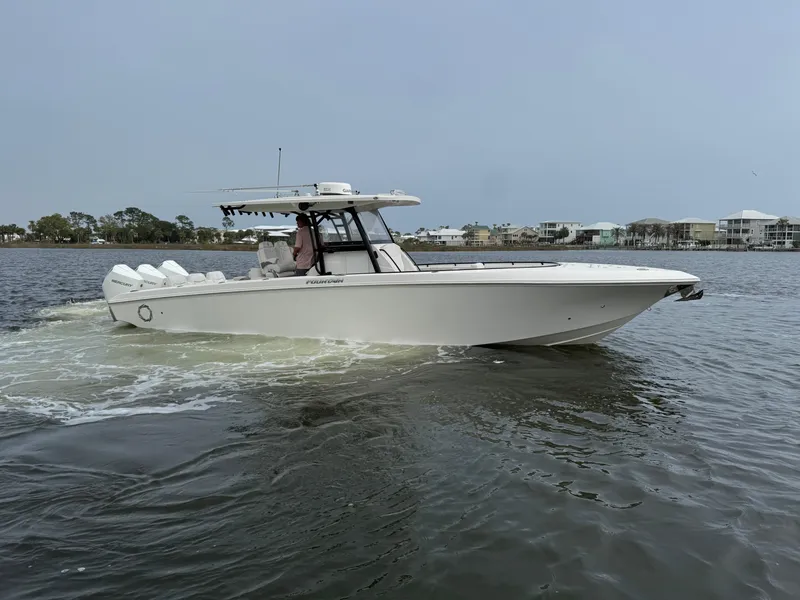 Slide: The Image of 2019 Fountain 34 CC boat cruising on calm waters near coastal buildings. - 9