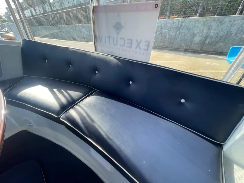 Slide: The Image of 2014 Duffy 18 Snug Harbor boat interior with black cushioned seating. - 17