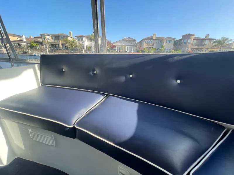 Slide: The Image of Interior seating of a 2014 Duffy 18 Snug Harbor boat with waterfront view. - 18