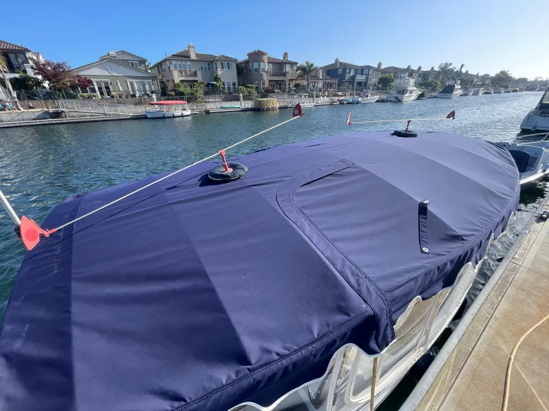Slide: The Image of Covered 2014 Duffy 18 Snug Harbor boat docked by waterfront homes. - 22