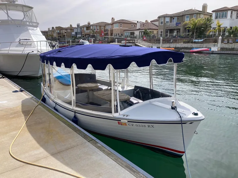Slide: The Image of 2014 Duffy 18 Snug Harbor electric boat docked with blue canopy. - 3