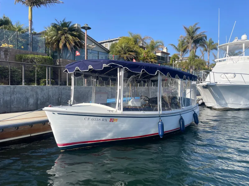 Slide: The Image of 2014 Duffy 18 Snug Harbor boat docked, featuring a blue canopy and scenic waterfront background. - 4