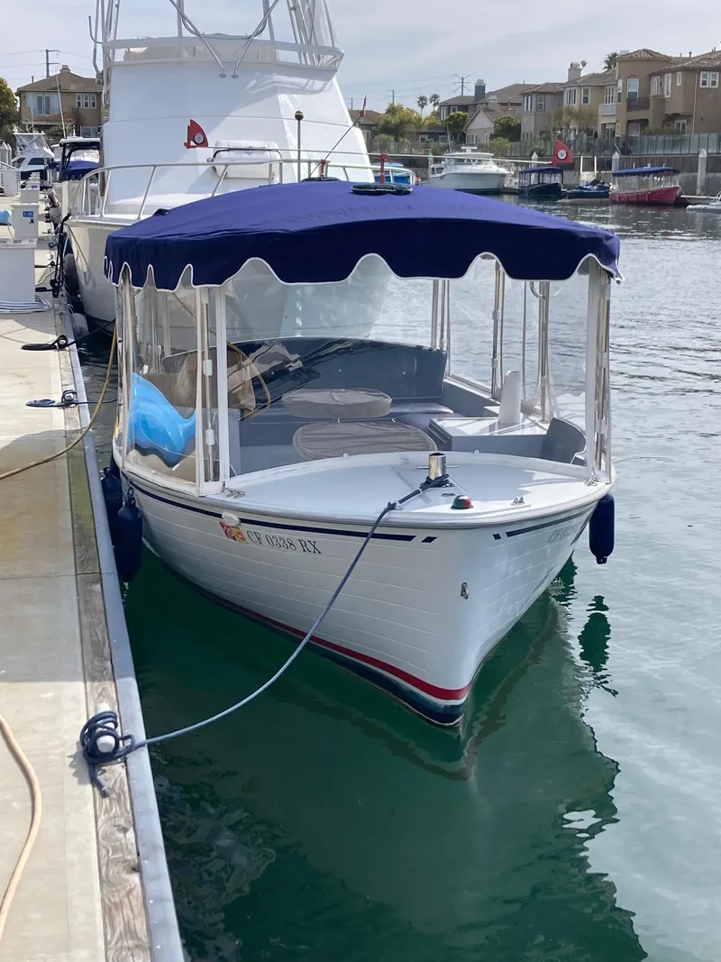 Slide: The Image of 2014 Duffy 18 Snug Harbor boat docked in a marina with blue canopy. - 6