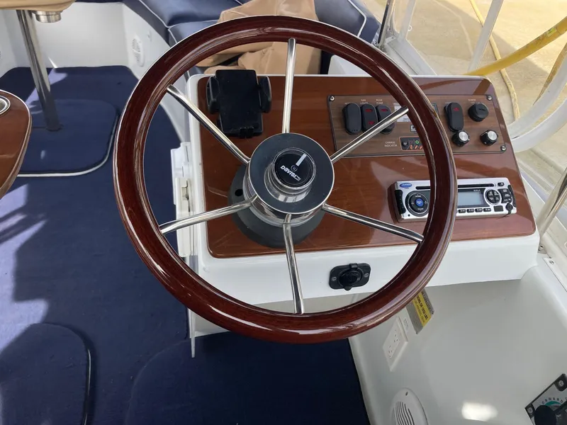 Slide: The Image of Steering wheel and controls of a 2014 Duffy 18 Snug Harbor boat. - 9