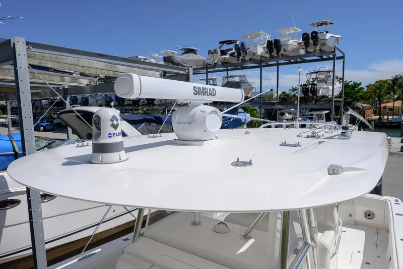 Slide: The Image of 2022 SeaVee 390Z boat with radar equipment, docked in a marina under clear skies. - 14