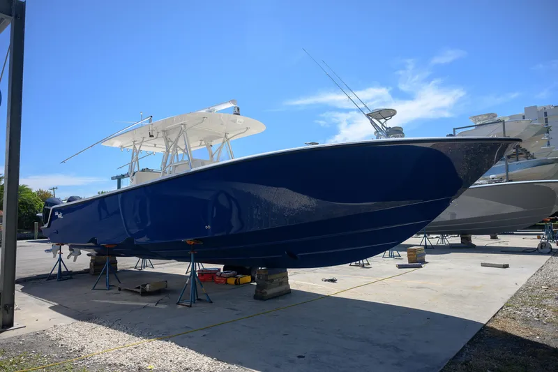 Slide: The Image of 2022 SeaVee 390Z boat in dry dock, blue hull, clear sky background. - 2