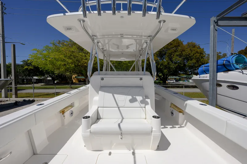 Slide: The Image of 2022 SeaVee 390Z boat with white seating and T-top, docked outdoors. - 8