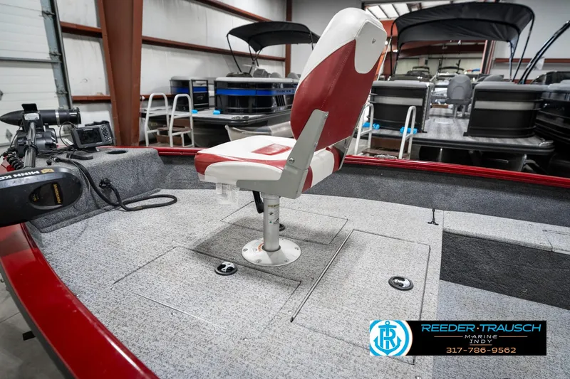 Slide: The Image of 2021 Tracker Super Guide 17 boat interior with red and white seating in showroom. - 20