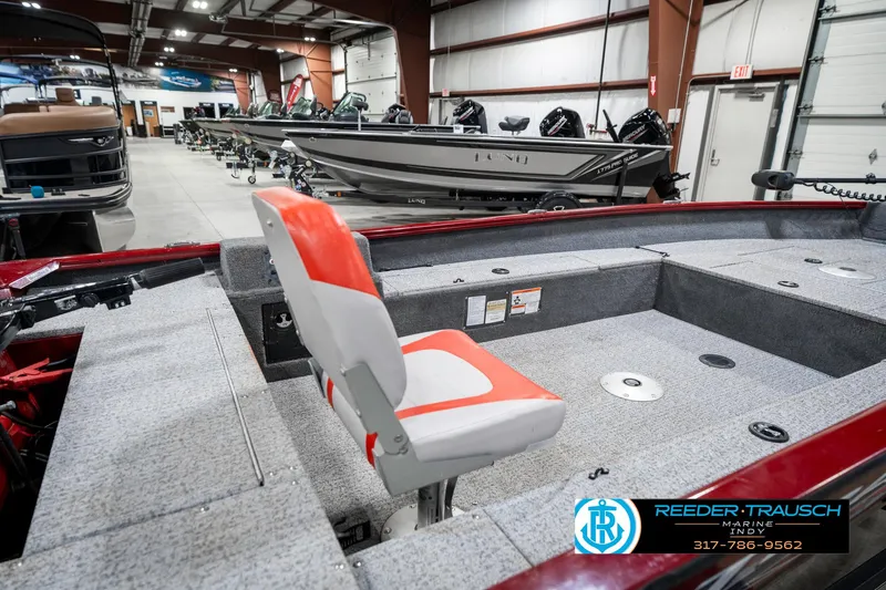 Slide: The Image of 2021 Tracker Super Guide 17 boat interior with red and gray seating in showroom. - 23