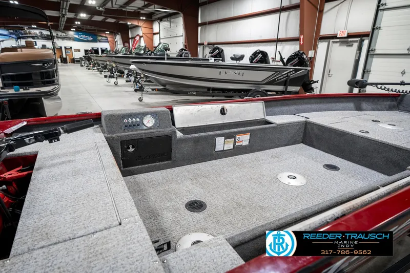 Slide: The Image of 2021 Tracker Super Guide 17 boat interior in showroom, featuring spacious deck and storage compartments. - 26