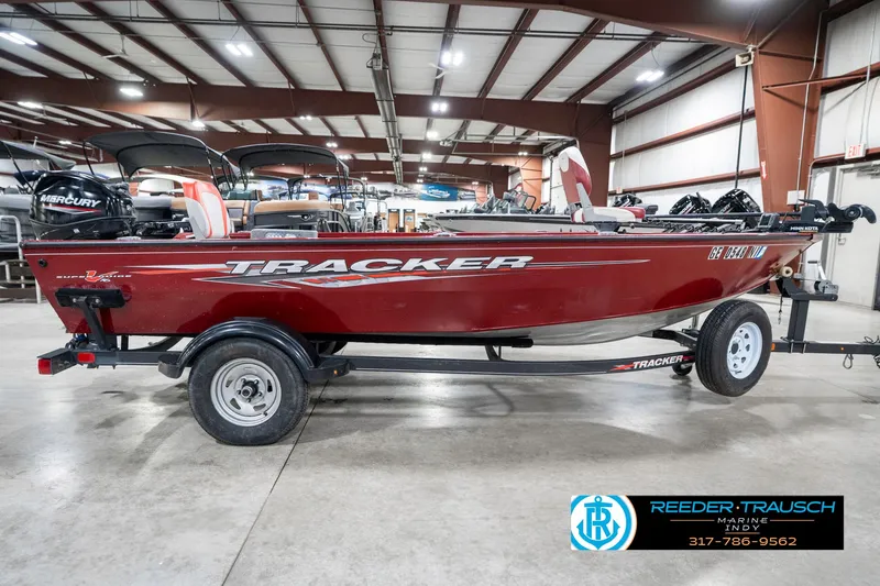 Slide: The Image of 2021 Tracker Super Guide 17 boat in a showroom, red exterior, side view. - 5