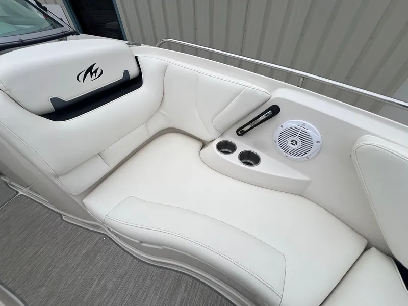 Slide: The Image of 2009 Monterey 254FS boat interior with white seating, speaker, and cup holders. - 11