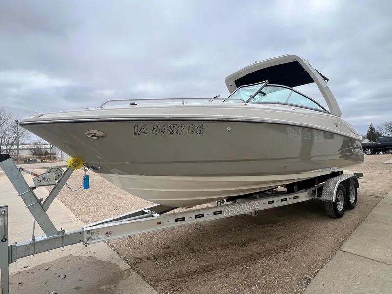 Slide: The Image of 2009 Monterey 254FS boat on trailer, parked outdoors under cloudy sky. - 2