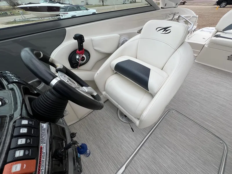 Slide: The Image of 2009 Monterey 254FS boat interior with steering wheel and white captain's chair. - 20