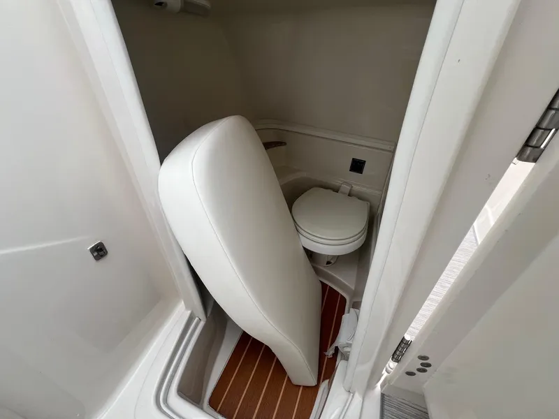 Slide: The Image of Interior of a 2009 Monterey 254FS boat showing a compact bathroom with a toilet. - 22