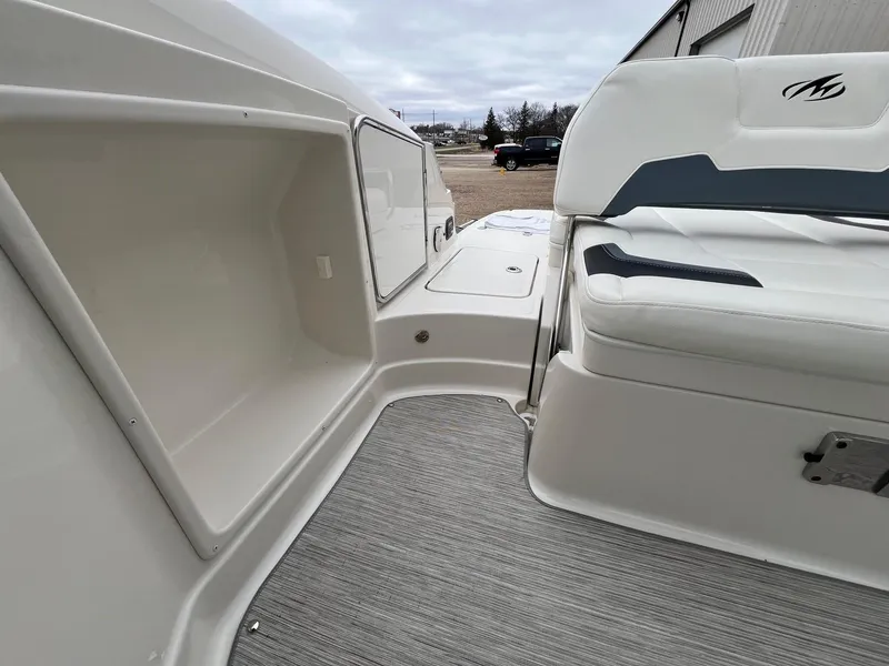 Slide: The Image of 2009 Monterey 254FS boat interior with white seating and storage compartment. - 24