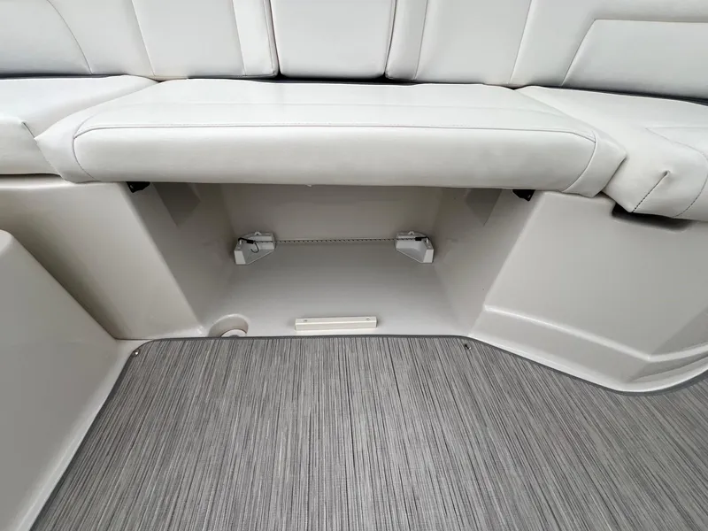Slide: The Image of 2009 Monterey 254FS boat interior with white seating and storage compartment. - 27