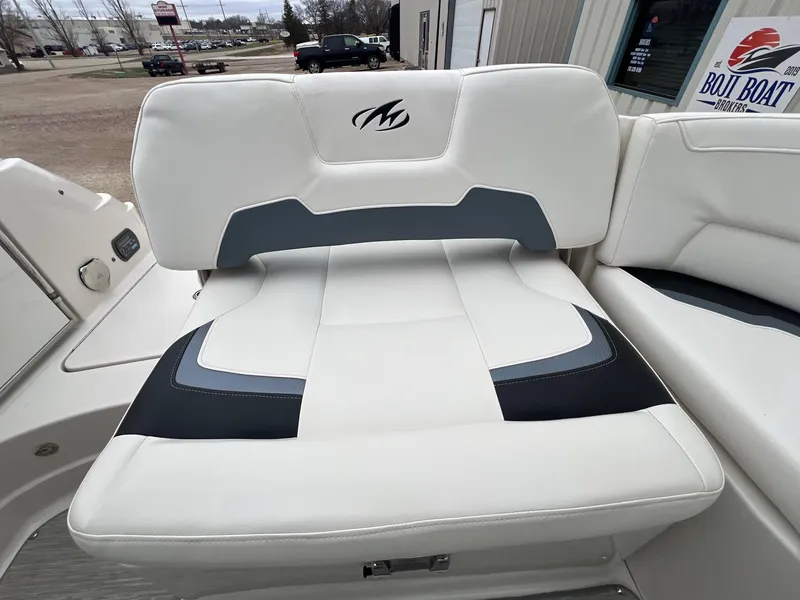 Slide: The Image of 2009 Monterey 254FS boat seat with white and gray upholstery, outdoor setting. - 28