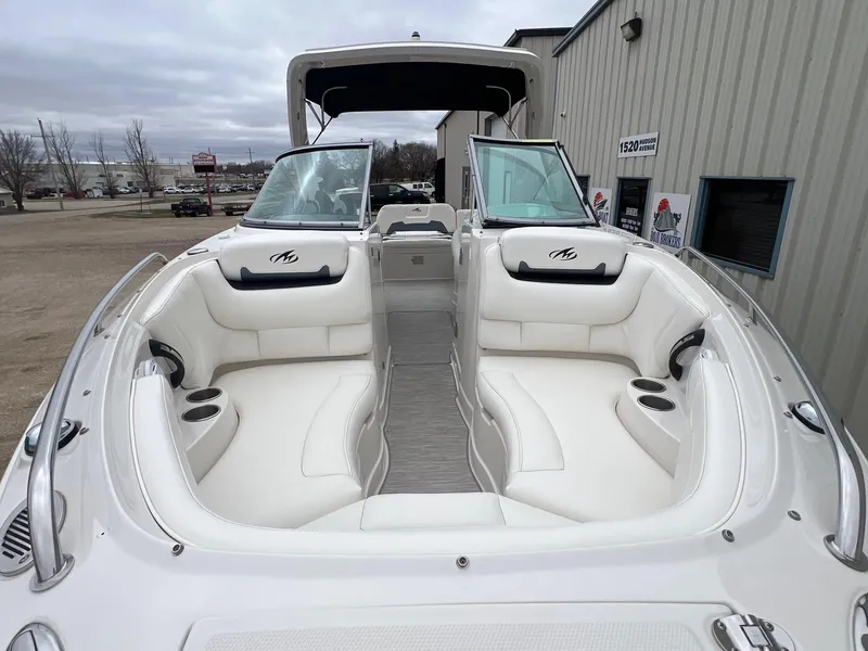 Slide: The Image of 2009 Monterey 254FS boat with white seating and open deck, parked outdoors. - 3