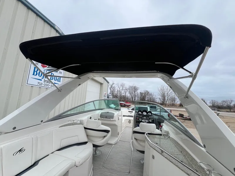 Slide: The Image of 2009 Monterey 254FS boat interior with seating and helm, under a black canopy. - 37