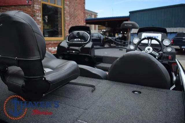 Slide: The Image of 2020 Nitro Z17 boat interior with black seats and steering wheel, parked near brick building. - 9