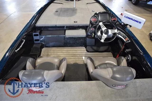 Slide: The Image of 2012 Stratos 294 XLE boat interior with steering wheel and seats, featuring Lowrance electronics. - 11