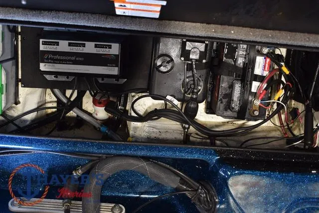 Slide: The Image of 2012 Stratos 294 XLE boat battery compartment with wiring and charger. - 29
