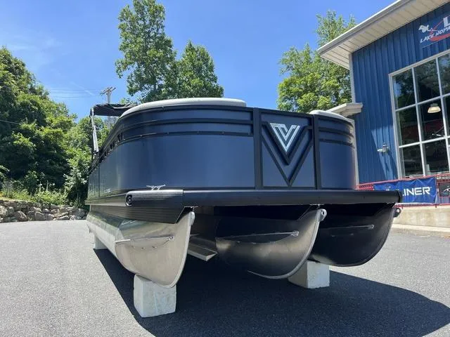 Slide: The Image of 2024 Viaggio Lago V-20C Triple pontoon boat displayed outdoors near a blue building. - 2