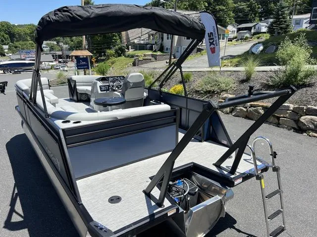 Slide: The Image of 2024 Viaggio Lago V-20C Triple pontoon boat with seating and canopy, parked on pavement. - 9